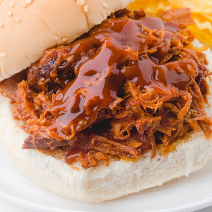 Pulled pork crock pot recipe served on a sandwich bun. It is juicy and tender with mouth watering barbecue sauce on the top.