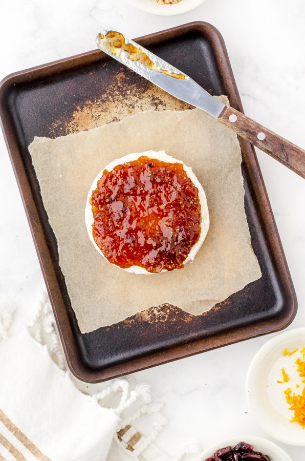 round of brie with fig jam spread on the top of it