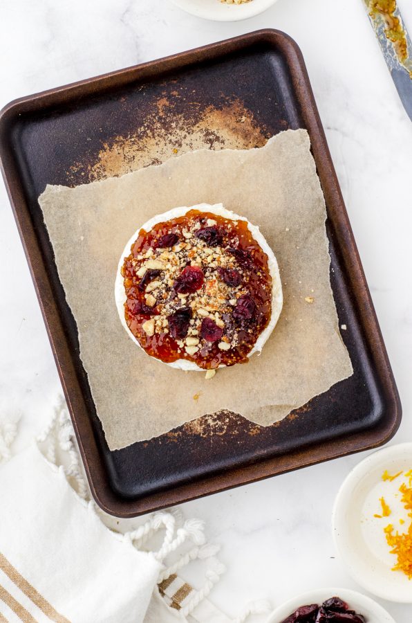 round of brie with fig jam, nuts and cranberries