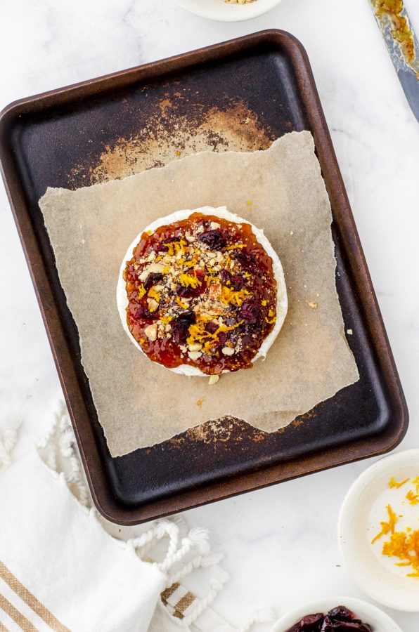 round of baked brie with fig jam, nuts, and cranberries - baked