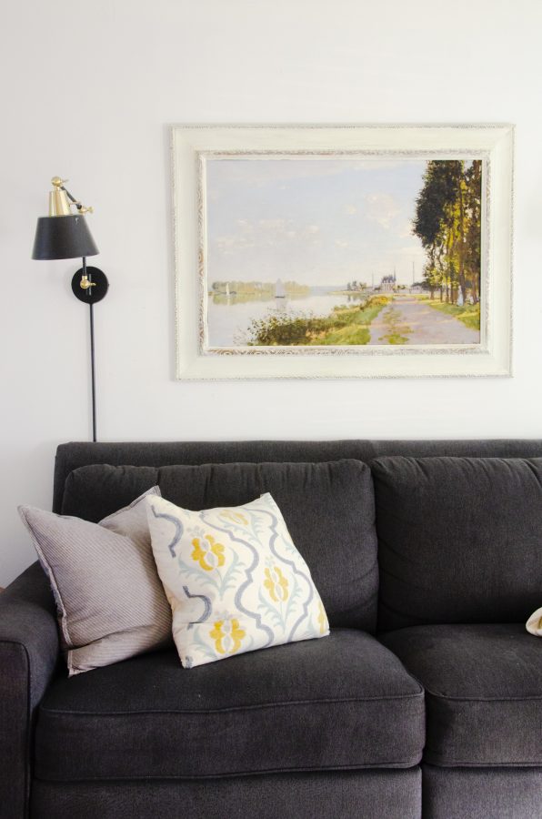 Vintage art print of Monet painting hanging above a couch.