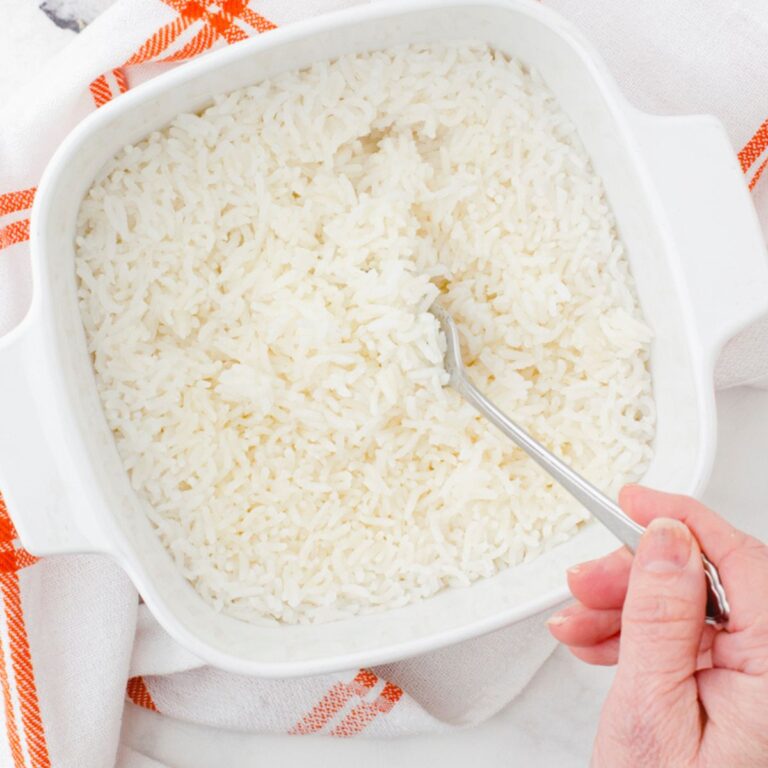 person fluffing oven baked rice with a fork