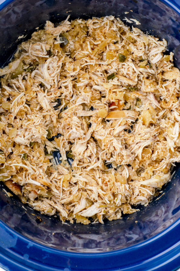 Shredded chicken in a crock pot mixed with the juices.