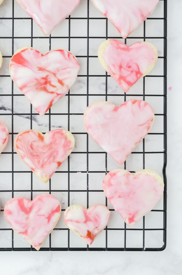heart cookies on a cooling rack with buttercream marble icing