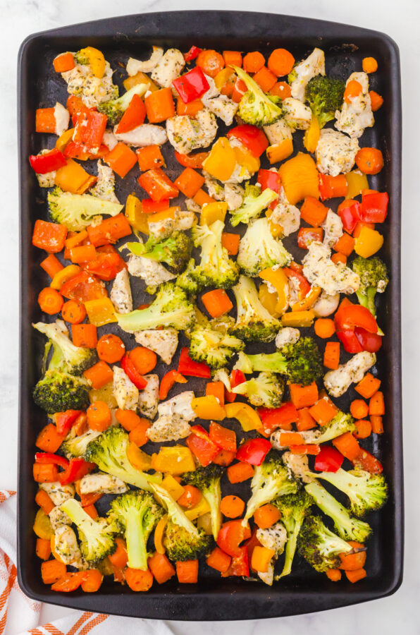 Sheet pan chicken and veggies on a sheet pan after it has been baked.