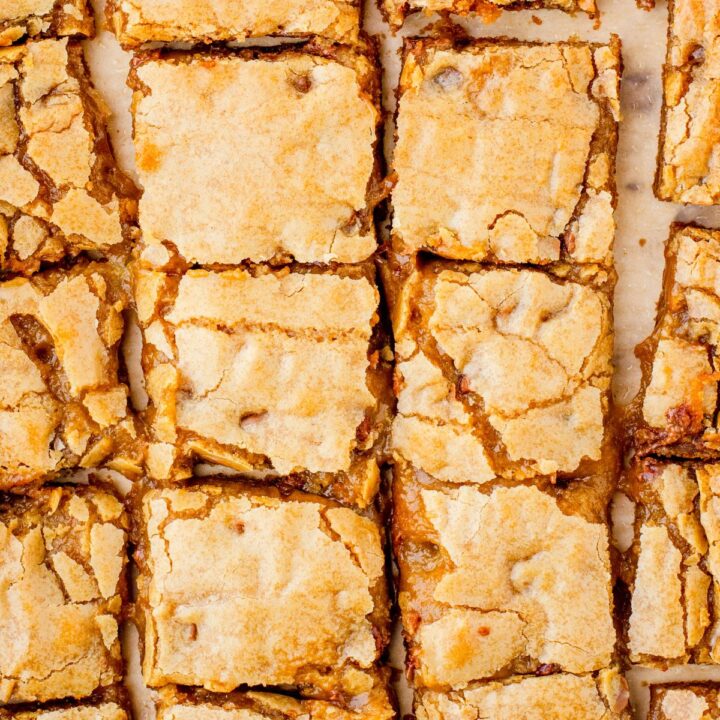 Butterscoth brownies recipe - otherwise known as blondies - cut in squares and sitting on parchment paper