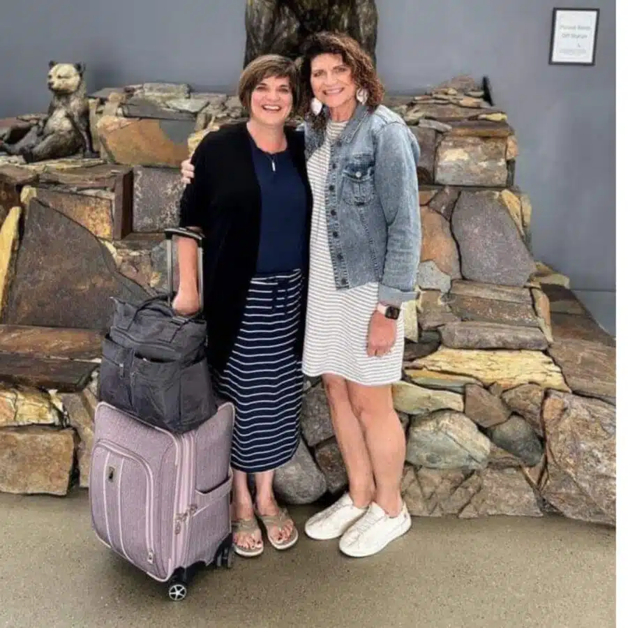 Picture of me and my sister in an airport with my travel bags in front of me.