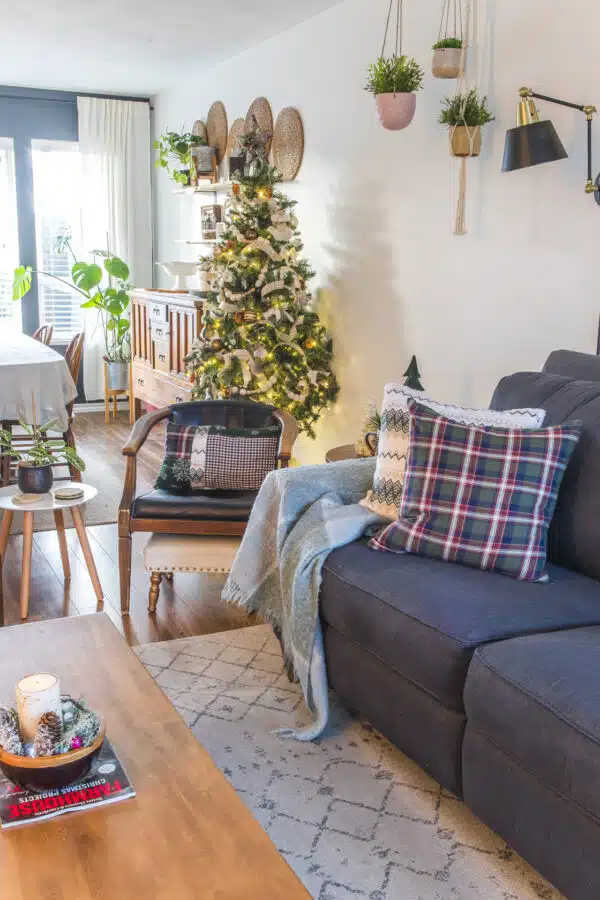 flannel pillow on a couch with a Christmas tree in the background showing some simple Christmas decor ideas.