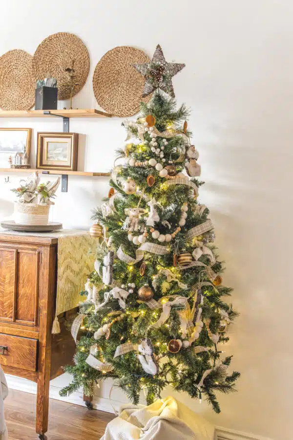 a christmas tree decorated in white garland, dried orange slices, and brown and gold ornaments