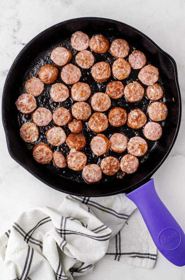 Mennonite Farmer's sausage sliced and browned in a cast iron skillet.