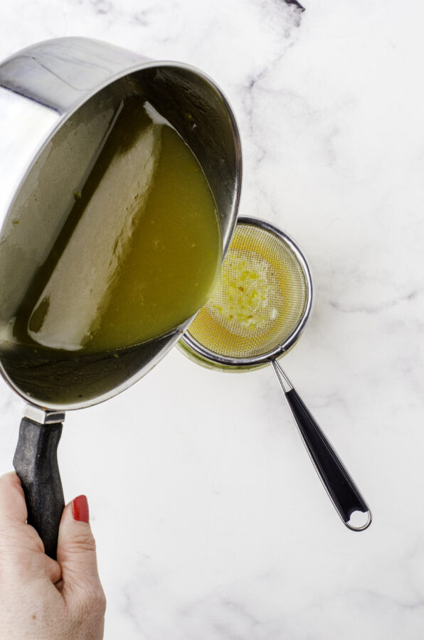 Mustard sauce for ham being strained with a small mesh strainer