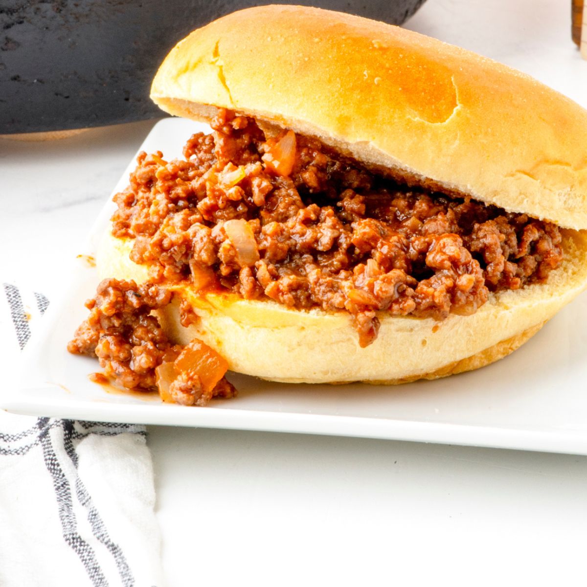 Classic old fashioned sloppy joes recipe in a bun on a serving plate