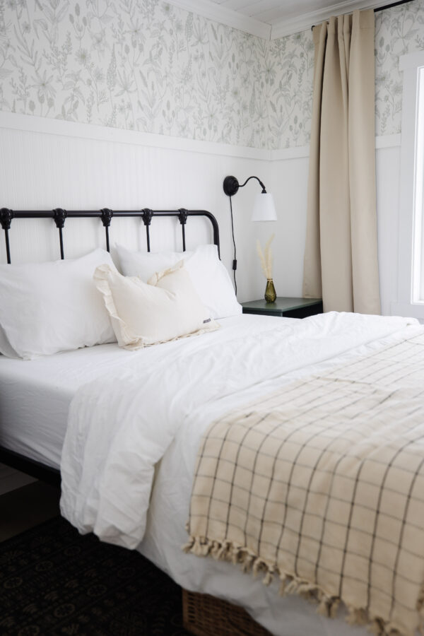 a bed made with beautiful white bed sheets and a throw blanket at the bottom of it.