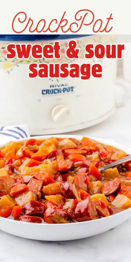 a crock pot with a big bowl of sweet and sour sausage and peppers in front of it.