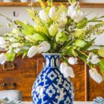 ginger jar vase with faux flower arrangment sitting on a table