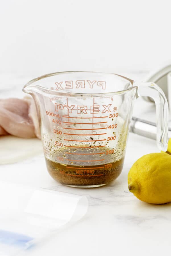 Greek chicken marinade ingredients whisked together in a large measuring cup.