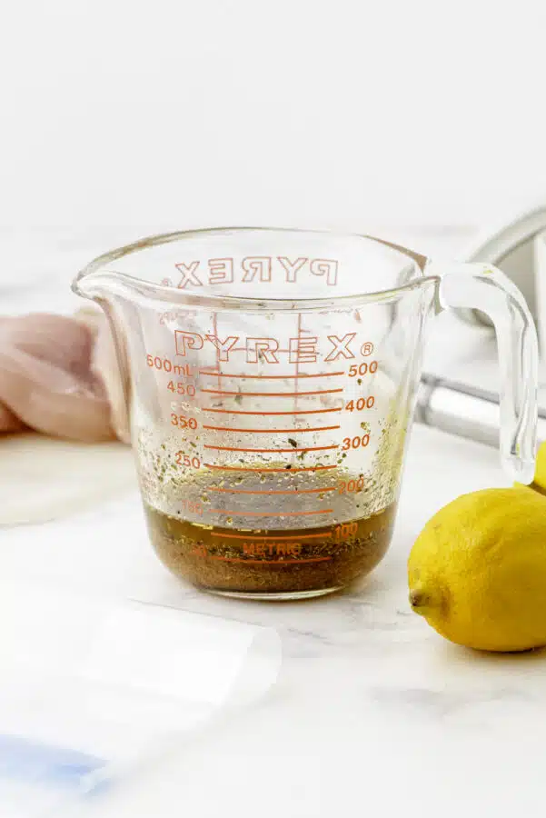 Greek chicken marinade ingredients whisked together in a large measuring cup.