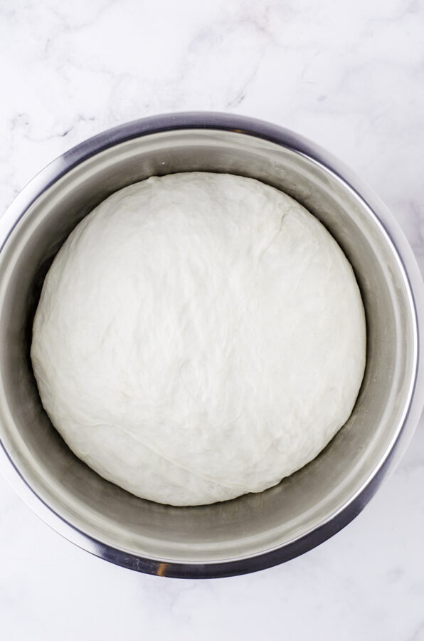 Sourdough bread dough after it has risen to over double in size in a large metal bowl.