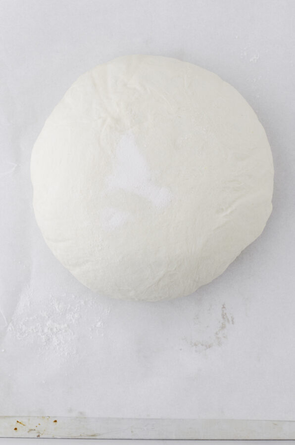 Put the proofed sourdough loaf onto a piece of parchment paper.