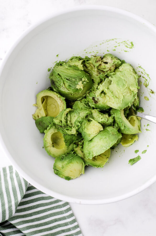 Avocado halves in a large bowl.
