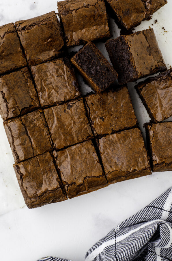 Sourdough discard brownies cut and laying out on a piece of parchment paper.