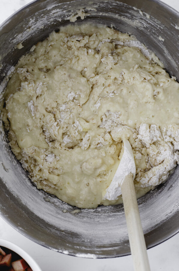 Rhubarb muffin batter being stirred together with a rubber spatula.