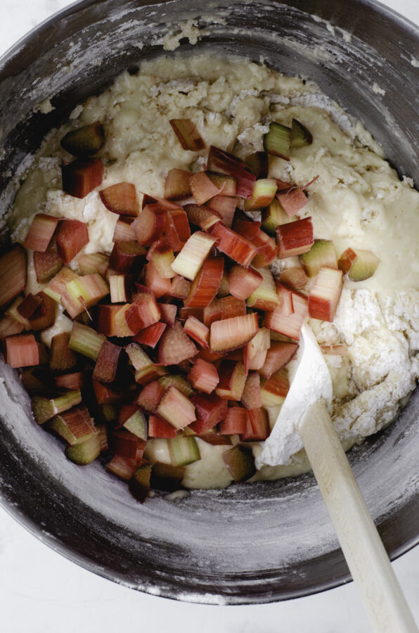 Diced rhubarb being added to sourdough muffin batter.
