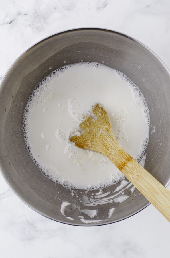 The water, sourdough starter and salt mixed together in the mixing bowl of a stand mixer so it is combined. Step 2 of mixing up sourdough bread dough