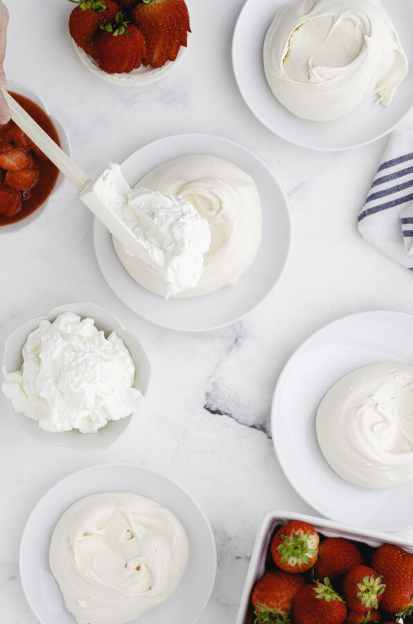 Whipping cream on an individual pavlova.