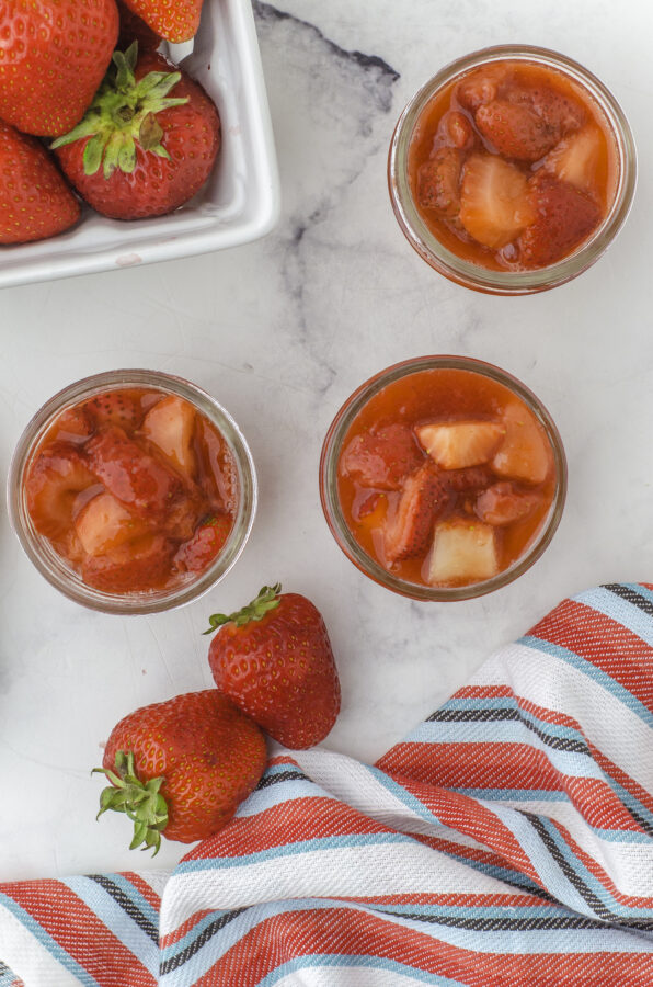 Strawberry sauce in 3 125 ml (small) mason jam jars.