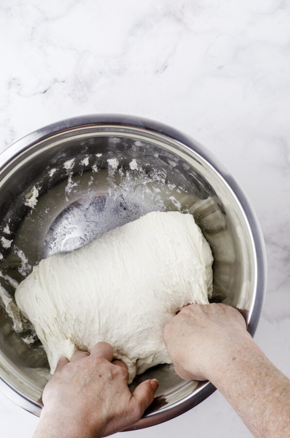 Folding the sourdough over itself in a large bowl.