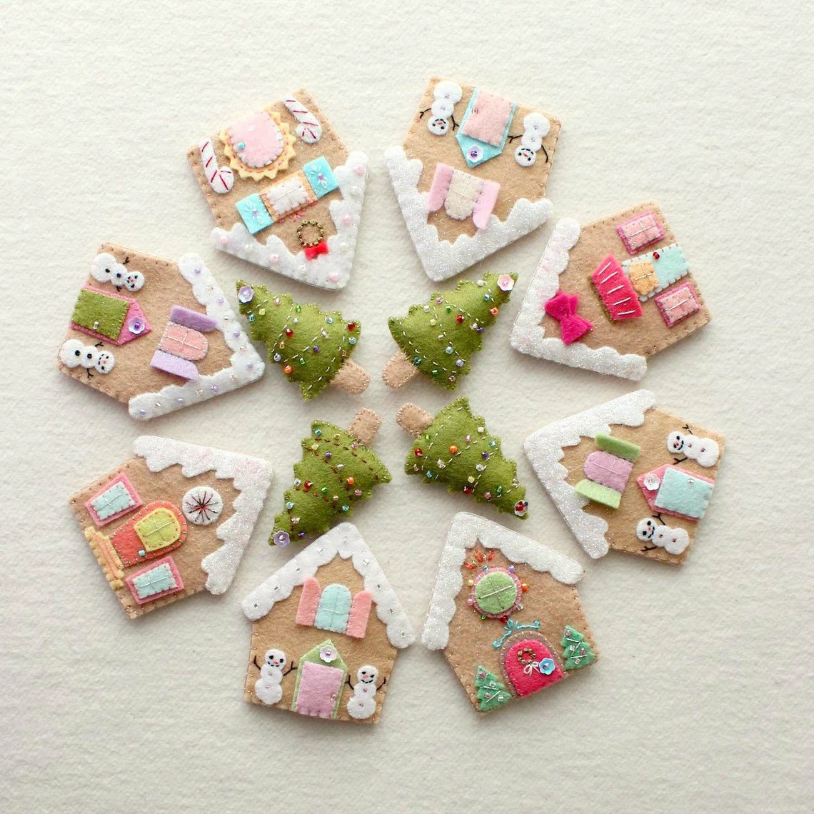 Felt gingerbread houses and trees arranged in a circle like a wreath