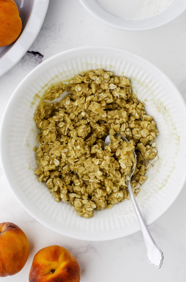 The mixed oat topping for peach crisp in a mixing bowl