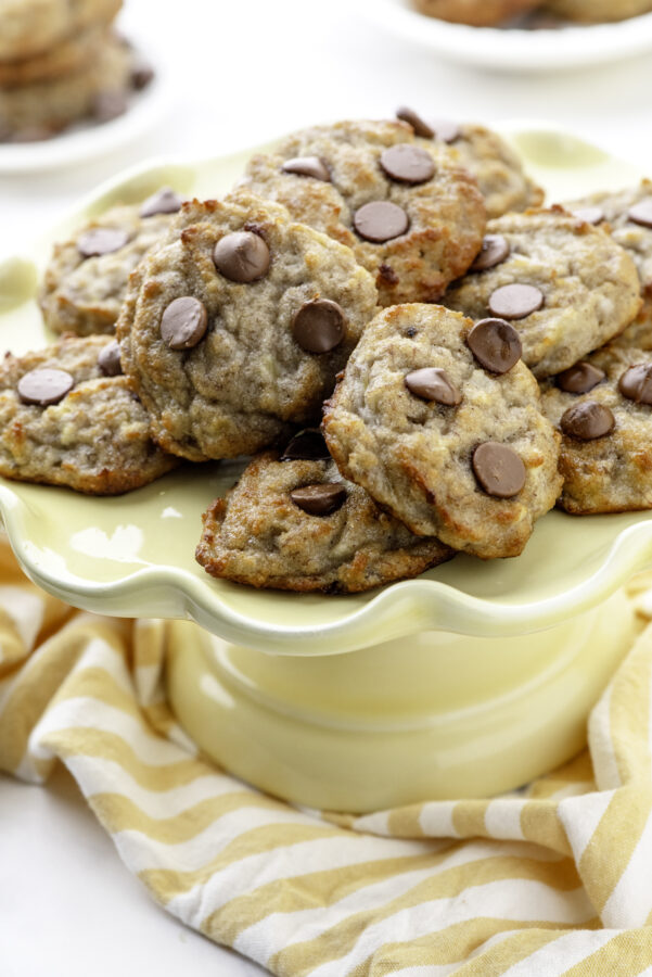 A yello plate with a stack of banana cookies on it.
