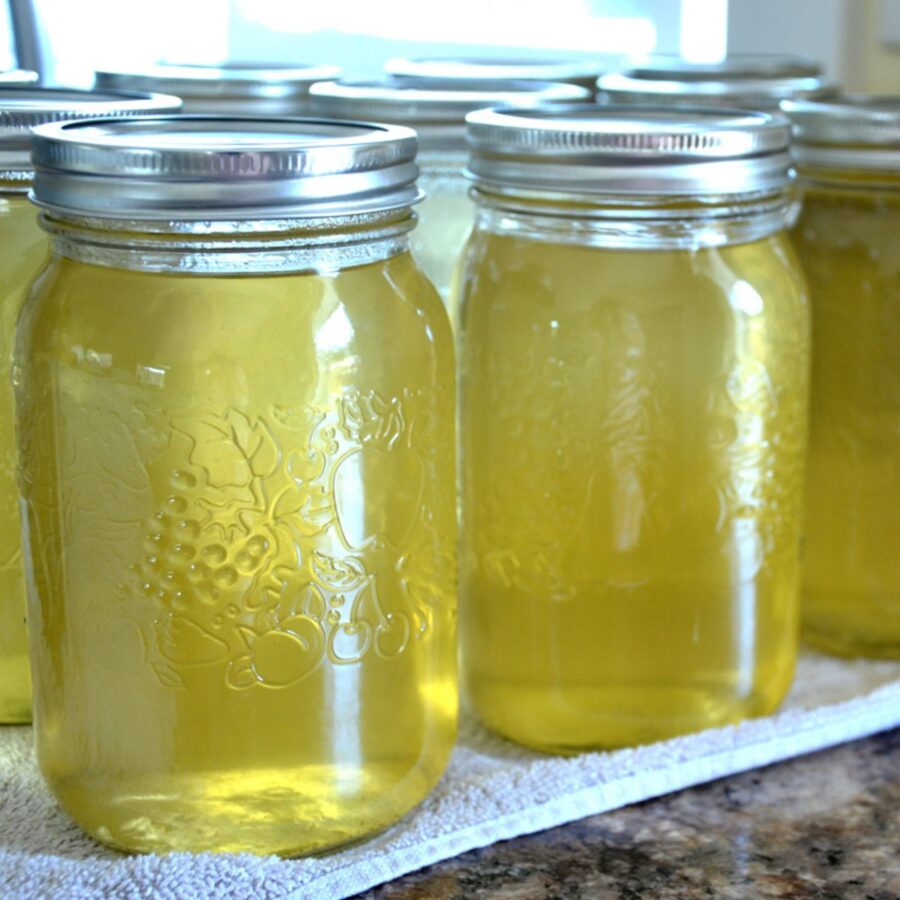 jars of homemade apple juice lined up on a counter