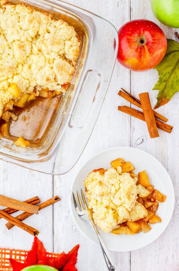 A dish of old fashioned apple cobbler beside a pan of cobbler.