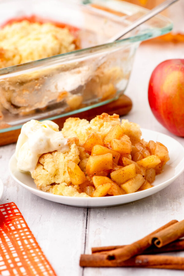A serving of apple cobbler with a scoop of vanilla ice cream on it.