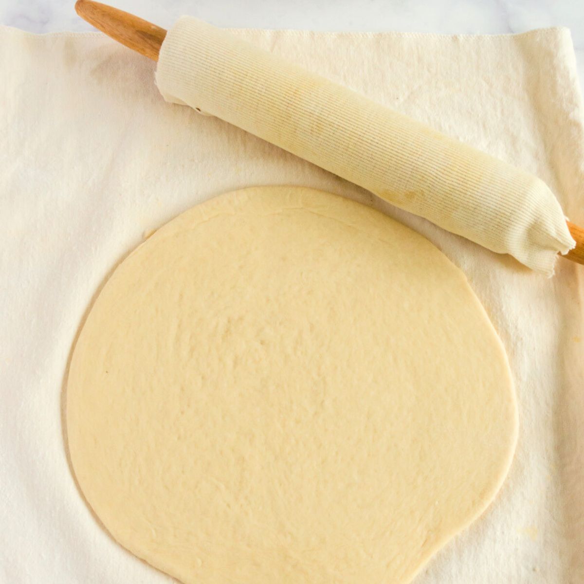 dough with an antique rolling pin and pastry cloth