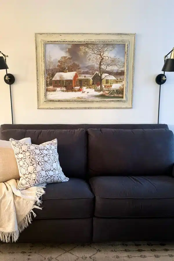 Vintage landscape art print framed and hung above a couch