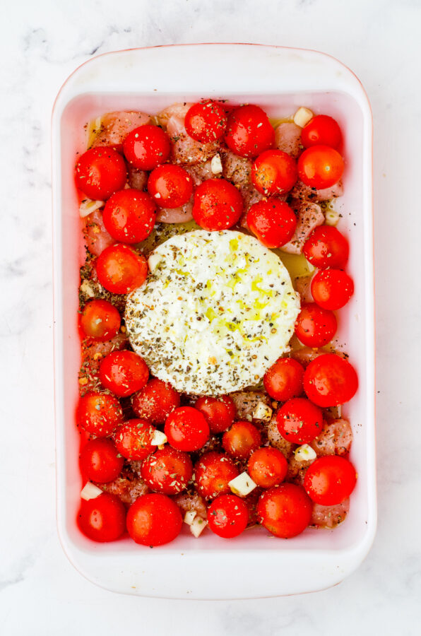 Feta chicken pasta sauce ingredients in a baking pan.