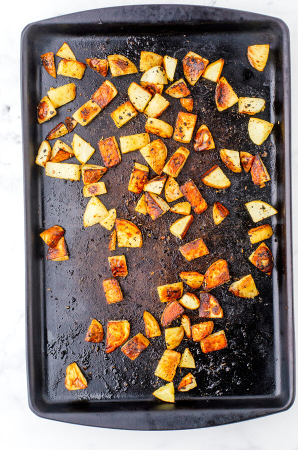 Roasted potatoes on a stoneware pan after they have been baked.