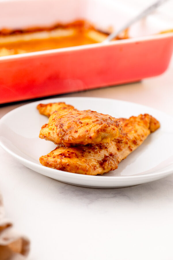 2 piecs of honey mustard chicken on dinner plate.