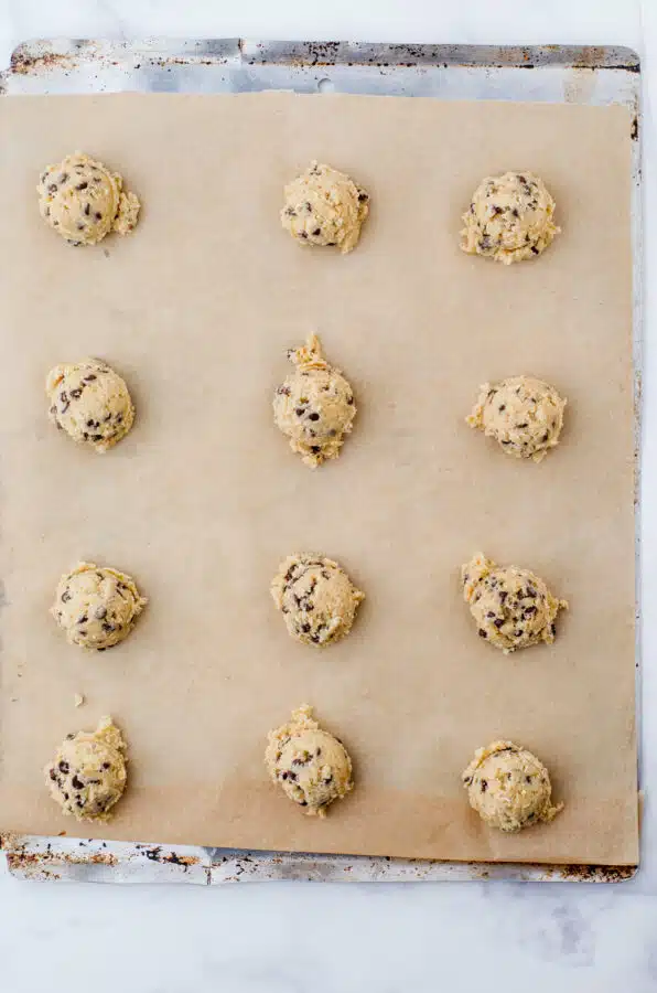 Cookie dough dropped onto parchment lined cookie sheet