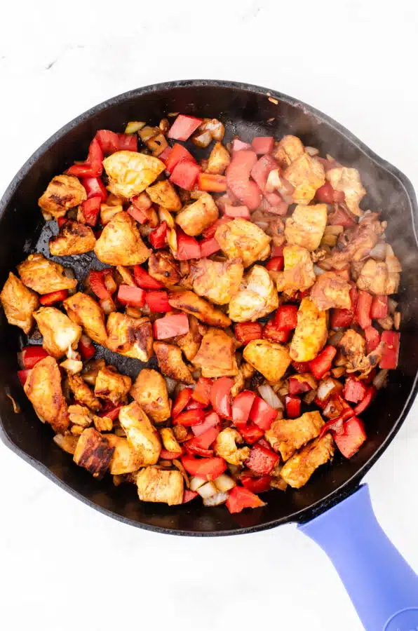 Sauted chicken and veggies in cast iron pan for one pot chicken pasta