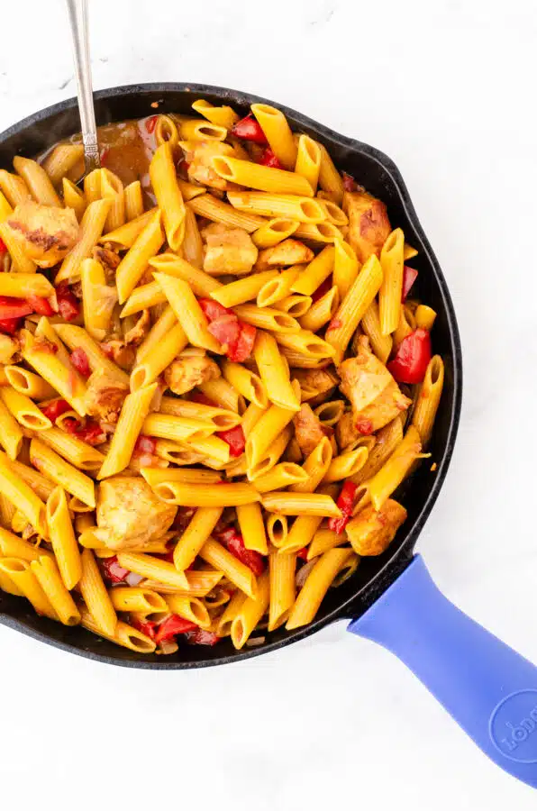 One pot chicken pasta in a skillet after the penne is cooked and the milk has been added.