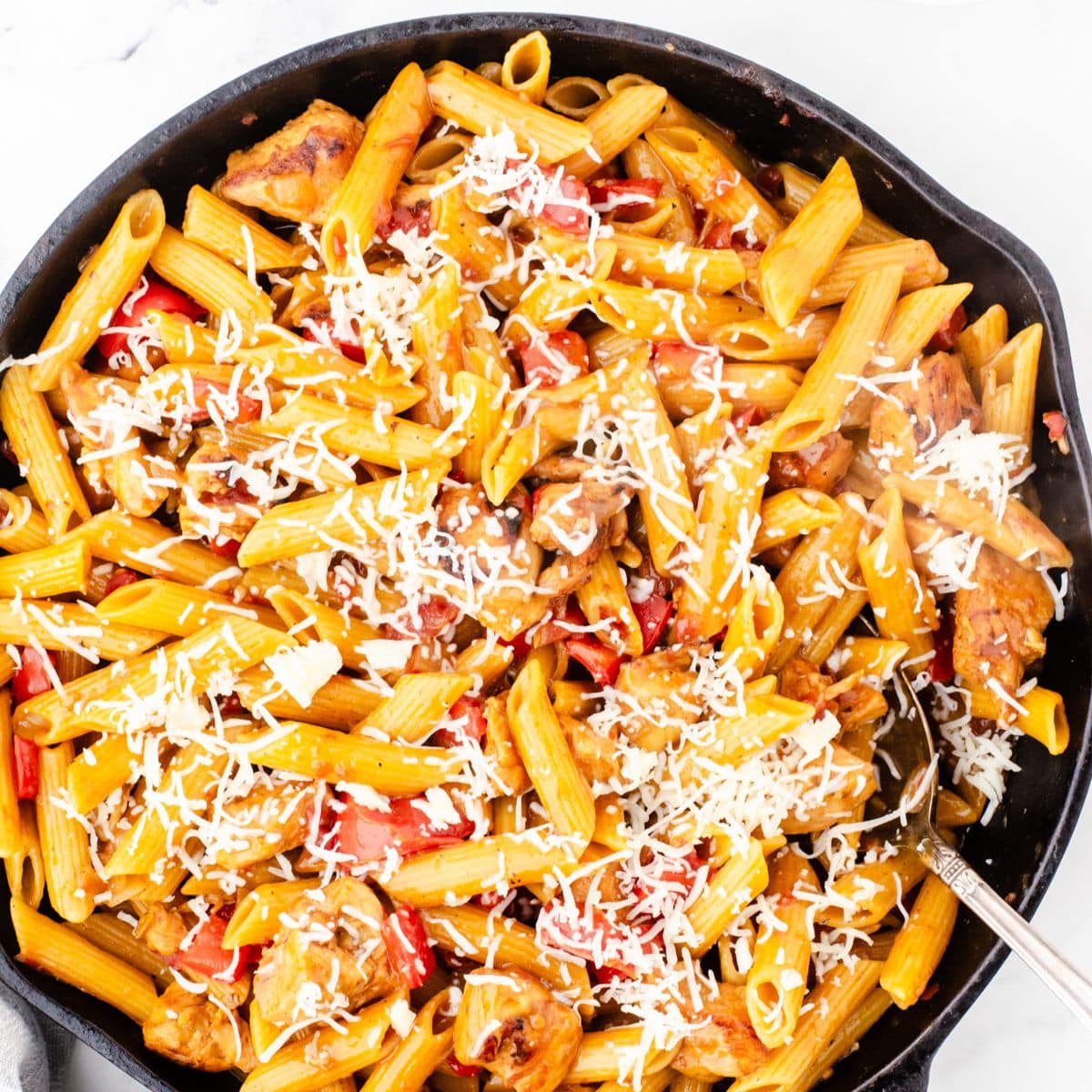 a cast iron skillet with one pot chicken pasta in it
