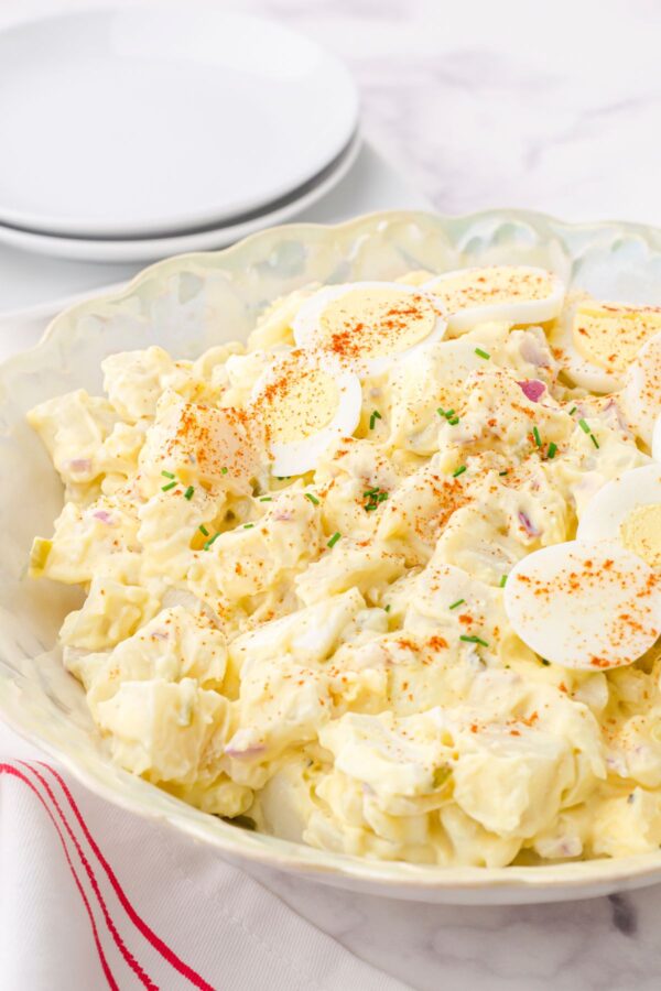 A serving dish full of classic potato salad with egg
