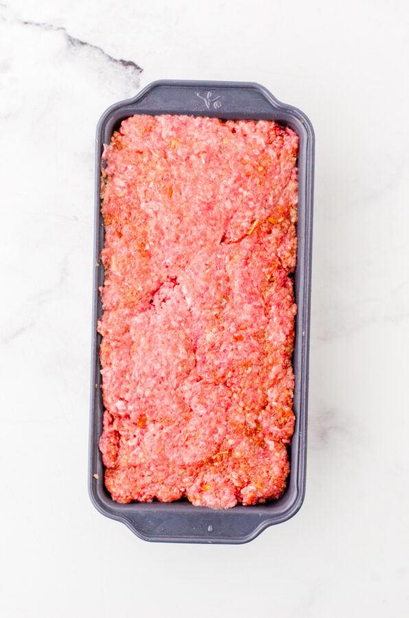 Pressed meatloaf mixture in a loaf pan.