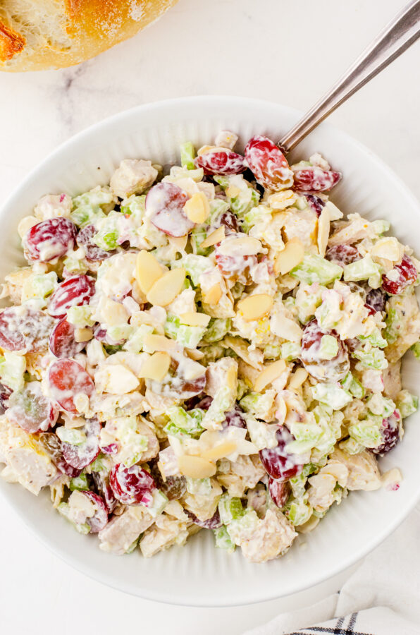 A bowl of chicken salad with sliced almonds on the top.