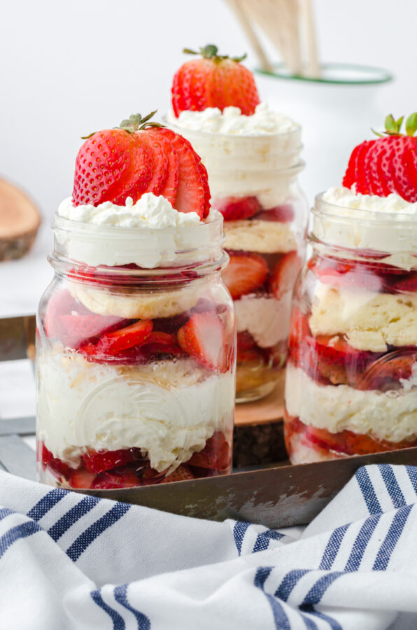 Strawberry shortcakes in a jar assembled and on a tray for serving.